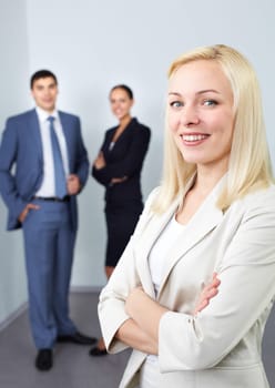 Portrait of young businesswoman with two colleagues in the background