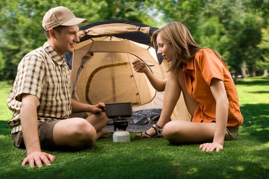 Photo of female tasting soup while her boyfriend looking at her in the park on sunny day