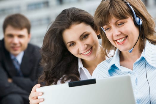 Portrait of two young business women looking in the laptop