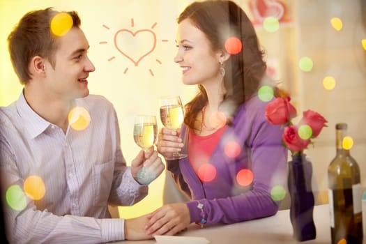 A young happy couple sitting in restaurant and drinking wine