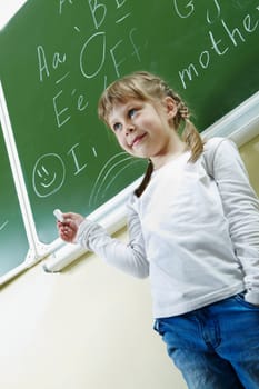 Image of smart schoolchild standing by the blackboard