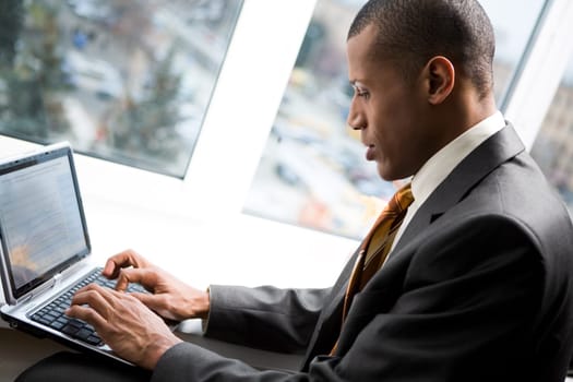 Photo of handsome employee working in office with laptop in front