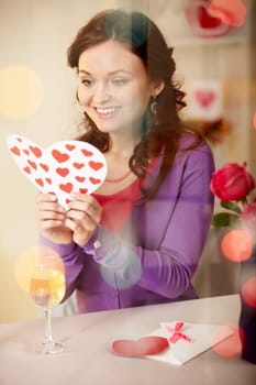 A young girl in restaurant holding Valentine card