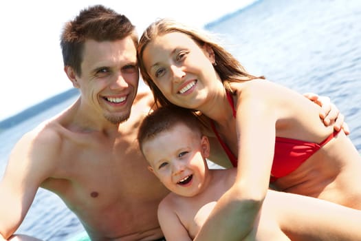 Photo of smiling family on summer vacation looking at camera