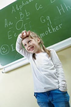 Portrait of smart schoolchild by the blackboard laughing