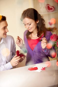 A young man showing engagement ring to his girlfriend