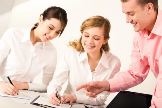 Image of young man pointing at paper in which pretty female going to write something