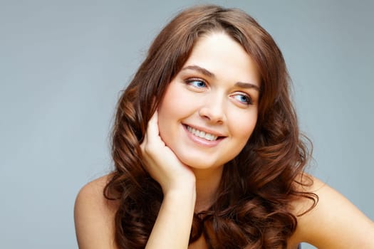 Portrait of feminine woman touching her face and looking aside
