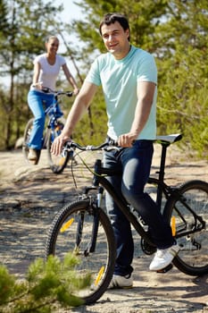 A man on bicycle looking at camera and smiling