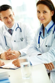 Portrait of confident female doctor with stethoscope looking at camera at workplace