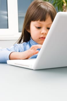 Close-up of childs palm over computer keyboard with female reader at background