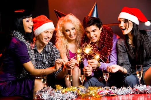 Portrait of laughing friends enjoying xmas lights at new year party