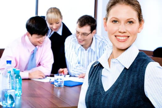 Portrait of beautiful white collar worker on the background of interacting business people