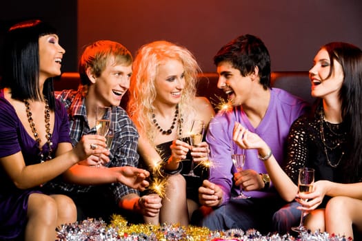 Portrait of joyful friends toasting with flutes of champagne at party