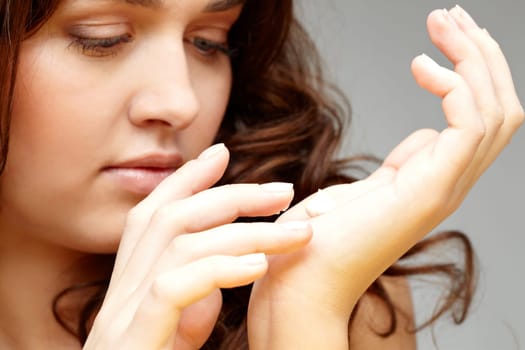 Image of female applying cream on her hands