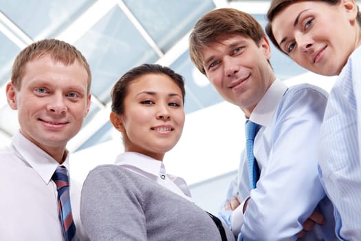 Four businesspeople looking at camera and smiling