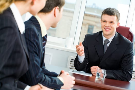 Confident boss proposes new terms of transaction to business partners at meeting