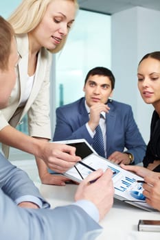 Businesswoman showing charts to colleagues