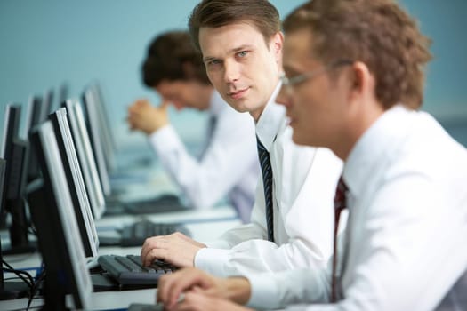 A businessman working on a computer among his colleagues