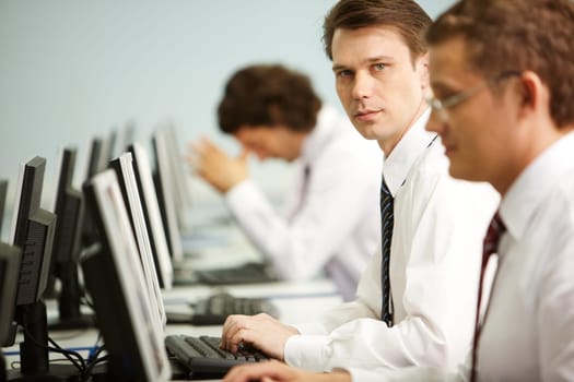 Image of smart businessman looking at camera in a working environment