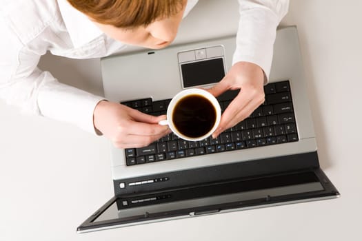 Photo of woman holding cup of coffee at workplace