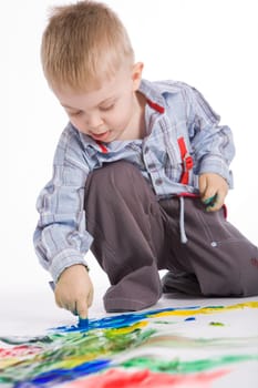 Photo of cute preschooler painting something with colorful gouache