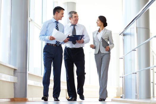 Confident business partners walking down and discussing work