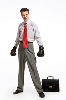 Portrait of aggressive businessman wearing boxing gloves over white background