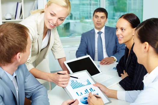 Group of business people discussing papers or sharing ideas in office