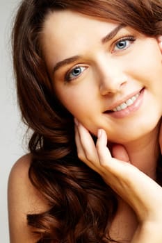 Portrait of charming girl touching her face and looking at camera
