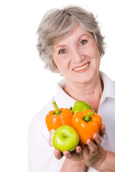 Portrait of aged female holding apples and peppers in hands