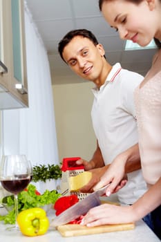 Portrait of amorous couple cooking salad in the kitchen