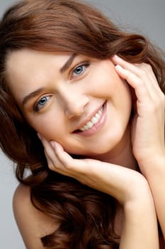 Portrait of charming girl touching her face and looking at camera