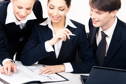 Photo of business women looking at documents at table with smiling man sitting near by