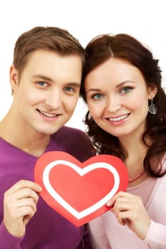 Portrait of a young beautiful couple holding paper heart and smiling