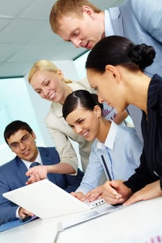 Business team looking at laptop screen while planning work at meeting