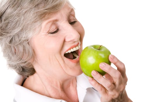Portrait of senior woman holding an apple and eating it