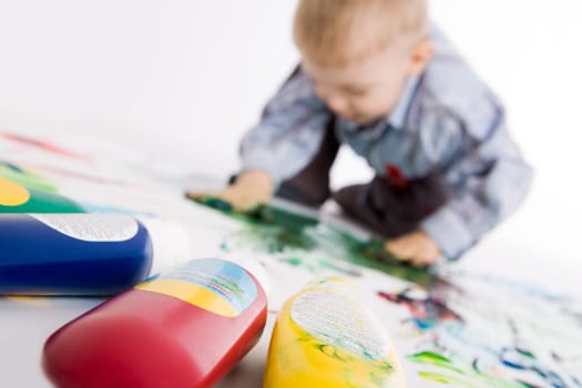 Photo of colorful gouache with painting kid at background