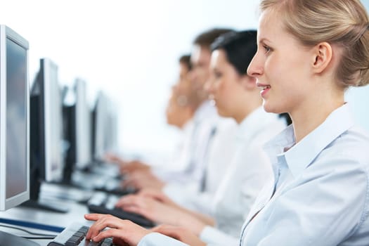 Close-up of a businesswoman working on computer among her colleagues