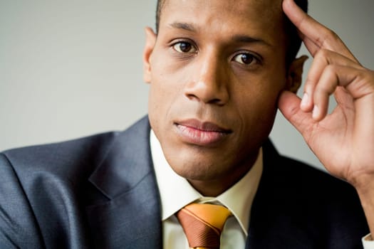 Pensive employee thinking of new ideas and looking at camera