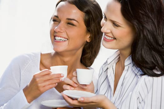 Portrait of two business women holding cups of coffee in their hands
