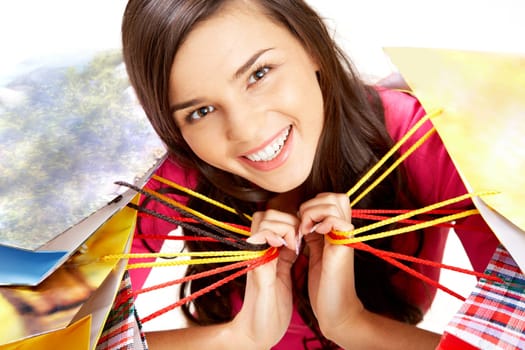 Portrait of happy girl with colorful paper bags looking at camera with smile