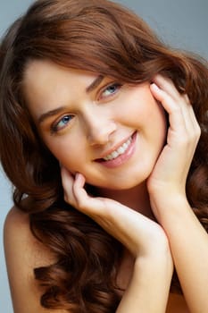 Portrait of charming girl touching her face and looking aside