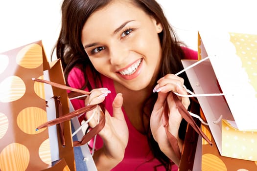 Portrait of happy girl with colorful paper bags looking at camera with smile
