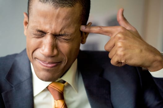 Image of confused man touching his temple with forefinger in trouble