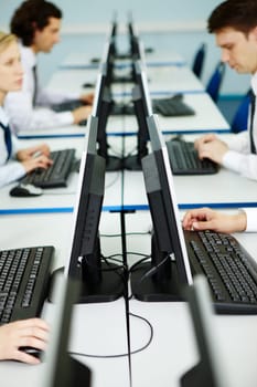 Business people sit at the tables with monitors on its in line