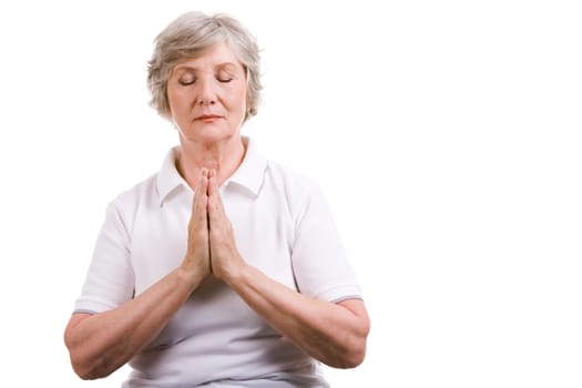 Portrait of mature woman praying with her hands put together and eyes shut