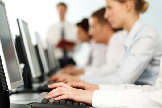Image of female hands typing on keyboard in a working environment