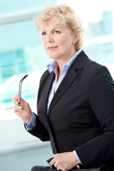 Portrait of smiling middle aged businesswoman with briefcase