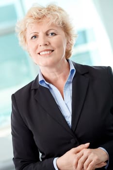 Portrait of smiling middle aged businesswoman looking at camera